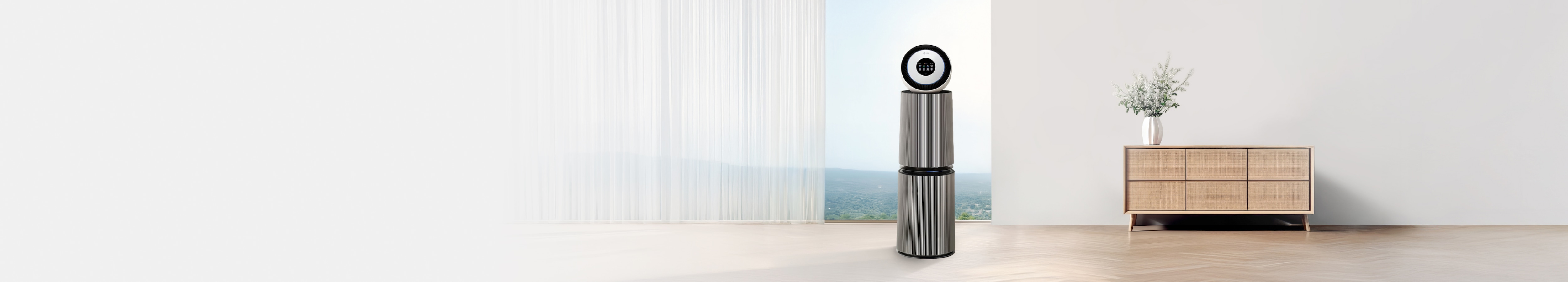 밝은 대리석 바닥에 LG 퓨리케어 AI 오브제컬렉션 360˚ 공기청정기가 놓여 있으며, 배경에는 흰색 벽과 창문이 있고, 창밖으로는 흐릿한 녹색 풍경이 보입니다. 공기청정기는 원통형 디자인으로 하단과 중간 부분이 세로 줄무늬가 있는 회색톤이며, 상단은 흰색 원형 패널과 검은색 테두리, 작은 디스플레이 화면으로 구성되어 있습니다.