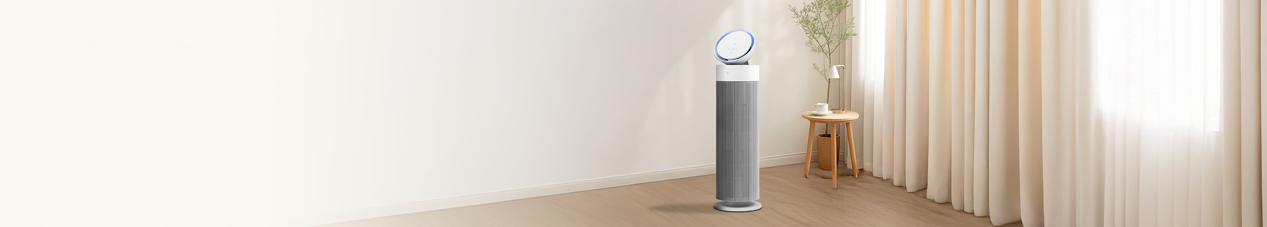 밝고 현대적인 거실에서 LG 퓨리케어 오브제컬렉션 에어로부스터가 중앙에 위치하며, 세련된 원통형 디자인과 상단의 기울어진 원반형 디스플레이가 특징입니다. 옆에는 화분으로 장식되어 있고, 뒤로는 창문이 햇빛을 받아 밝은 분위기를 조성합니다. 전체적으로 미니멀하고 깨끗한 공간을 연출합니다.