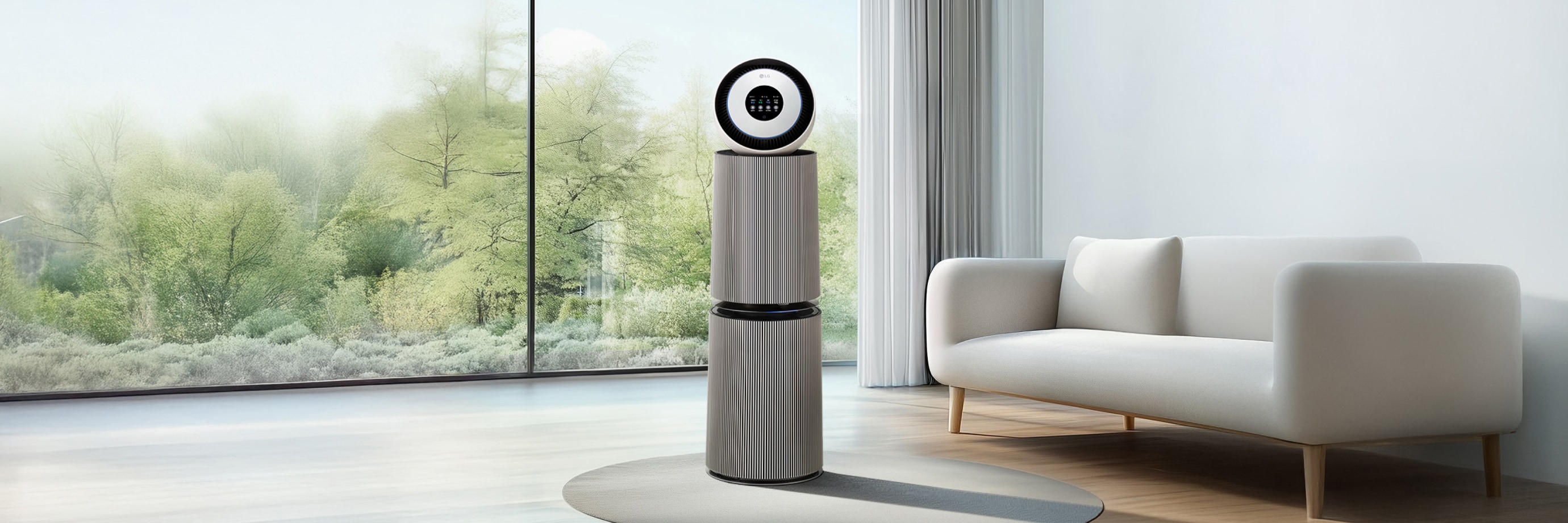 차분하고 깔끔한 거실 공간에 공기청정기가 놓여 있습니다. 원형 헤드와 세로 결 무늬가 돋보이는 본체 디자인이 세련된 분위기를 더하며, 옆에는 화이트 소파와 커튼이 어우러져 편안한 공간감을 연출합니다. 전면 유리창 너머로는 푸른 숲이 펼쳐져 자연과 조화로운 인테리어를 완성합니다.