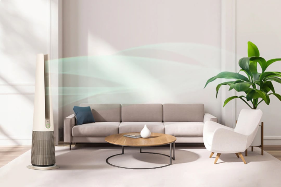 따뜻한 자연광이 드는 거실에 LG 퓨리케어 오브제컬렉션 에어로타워가 세워져 있으며, 소파와 테이블, 식물 등이 조화롭게 배치된 공간 속에서 부드러운 바람 흐름이 시각적으로 표현되어 쾌적한 실내 분위기를 보여줍니다.