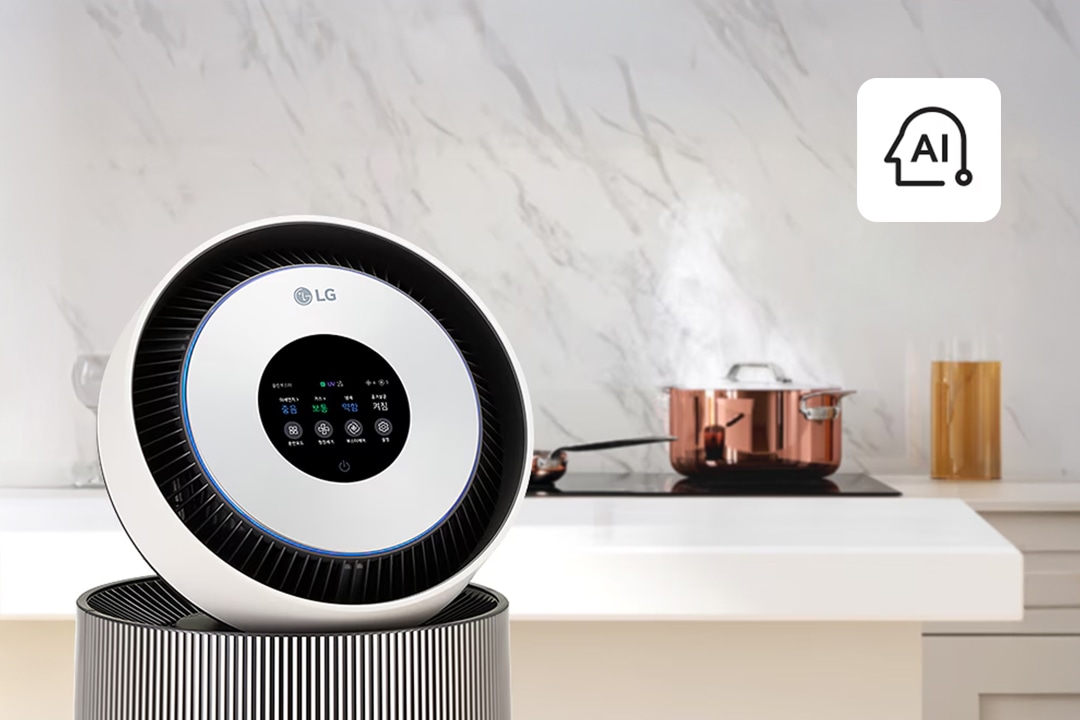 LG 공기청정기의 원형 디스플레이가 확대된 모습으로, 공기질 상태와 다양한 설정이 표시됨. 오른쪽 상단에는 AI 기능을 나타내는 아이콘이 있으며, 배경에는 주방 공간과 조리 중인 냄비가 보임.