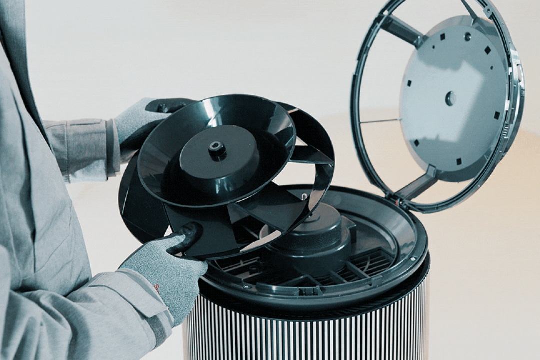 공기청정기 내부의 팬을 분리하는 장면을 보여주며, 유지 보수나 청소 과정의 용이함을 시각적으로 전달하고 있습니다. 상단 커버를 연 뒤 내부 팬을 손쉽게 탈착할 수 있는 구조를 강조하여 사용자 편의성을 부각합니다.