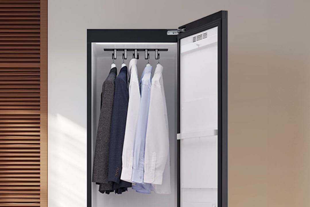 5벌용 스타일러가 열려있고, 안쪽에 다섯 개의 정장과 셔츠가 걸려있습니다.