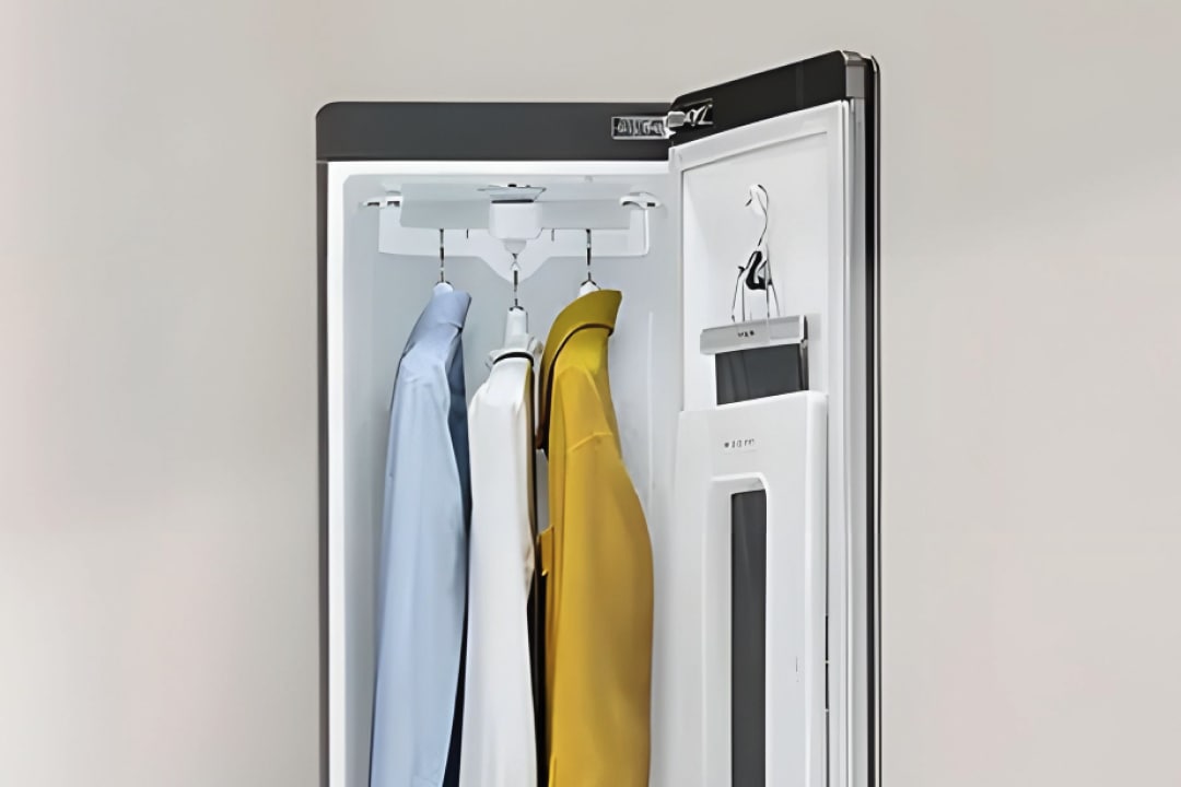 3벌용 스타일러가 열려있고, 안쪽에 세 개의 정장과 겉옷들이 걸려있습니다.