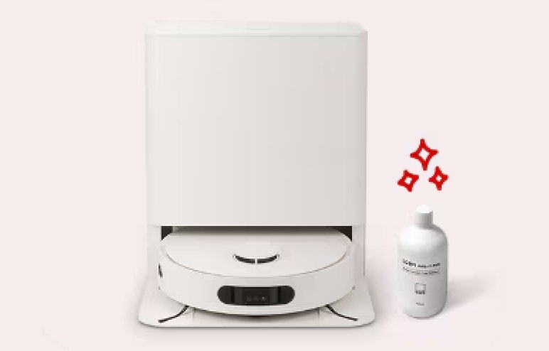 로봇청소기가 충전·관리 스테이션에 도킹되어 있고, 옆에는 세정제를 상징하는 병과 반짝임 그래픽이 배치되어 있어 물걸레 세척이나 관리 기능을 표현한 이미지입니다.