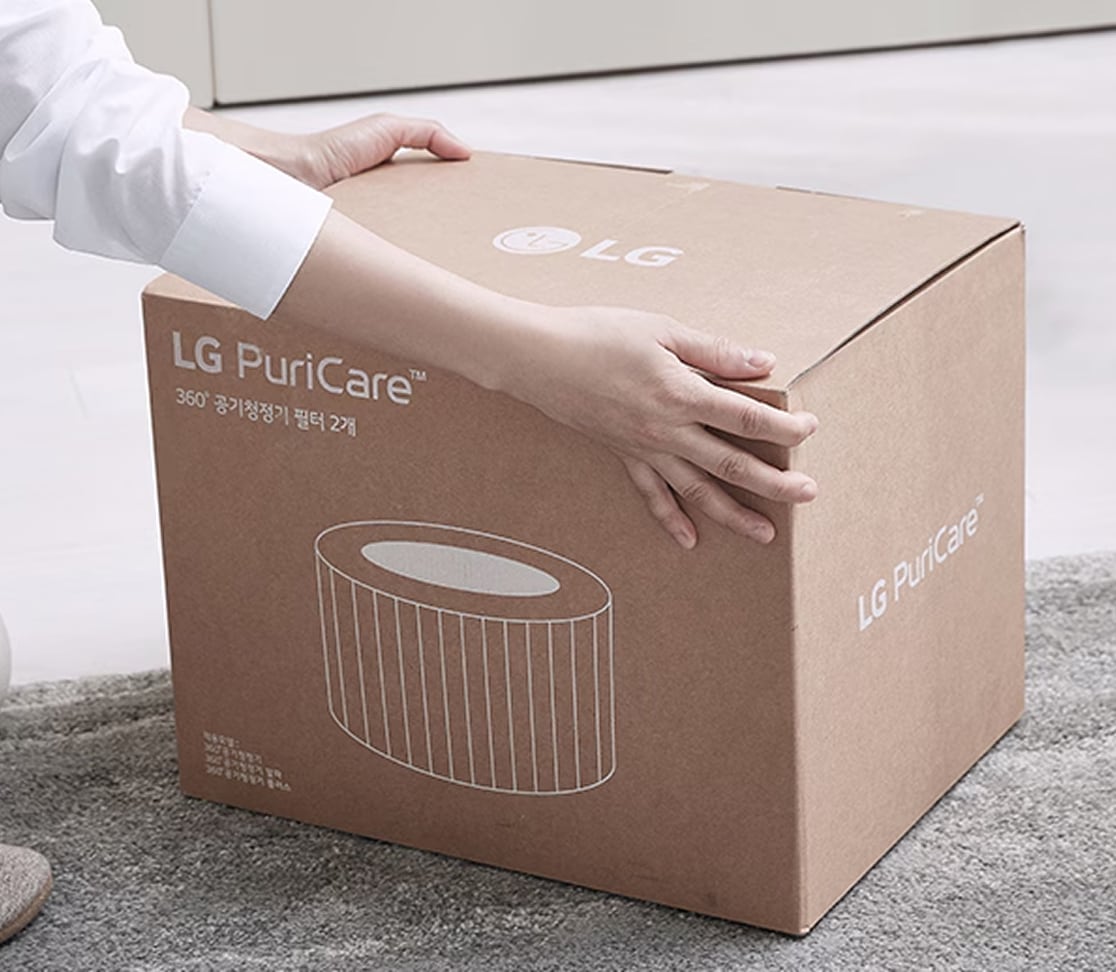 LG PuriCare 공기청정기 필터 박스를 손으로 잡고 있는 모습