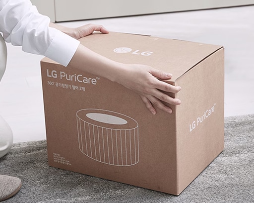 LG PuriCare 공기청정기 필터 박스를 손으로 잡고 있는 모습