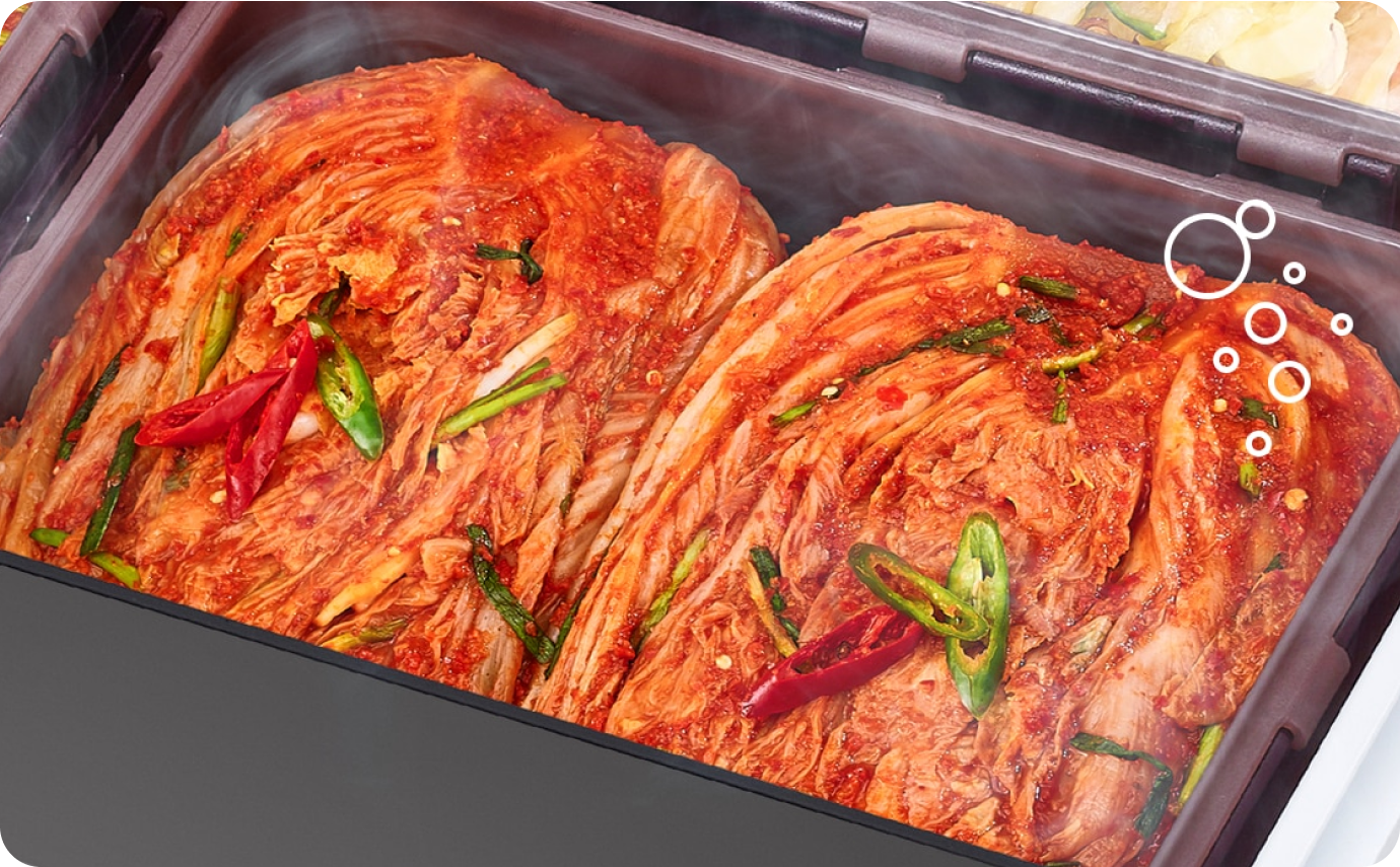 김치 냉장고 속 김치통에 잘 익은 김치가 담겨 있고 김치 위에 수증기 효과가 나타남