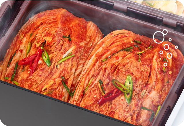 김치 냉장고 속 김치통에 잘 익은 김치가 담겨 있고 김치 위에 수증기 효과가 나타남