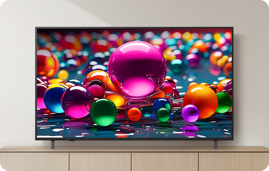 거실 벽에 설치된 LG TV 화면에 파도와 바위가 선명하게 담긴 바닷가 풍경이 표현된 모습.