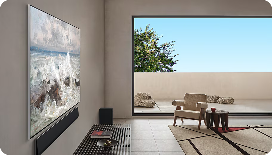거실 벽에 설치된 LG TV 화면에 파도 치는 바다 풍경 그림이 표현되어 있으며, 옆에는 큰 창을 통해 테라스와 푸른 하늘이 보이는 모습.