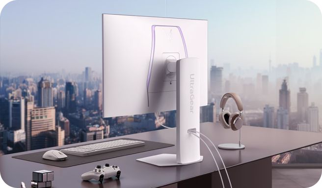 도시 전경이 보이는 창가에 놓인 책상 위에 LG UltraGear 모니터 뒷면이 보이는 모습.