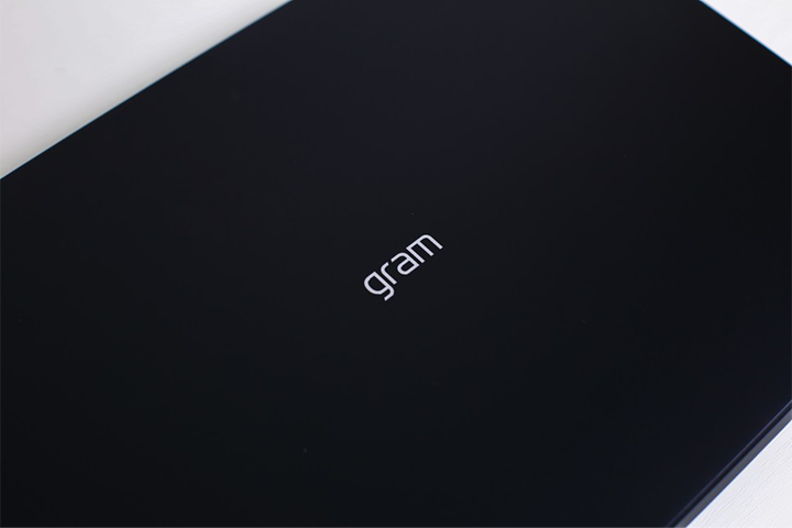 닫힌 검정색 LG 그램 노트북의 상판 중앙에 새겨진 'gram' 로고가 클로즈업된 모습