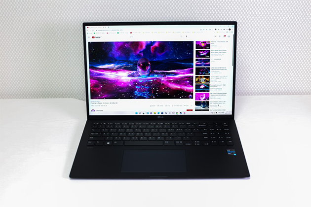 LG 그램 노트북이 열려 있는 정면 모습으로, 화면에는 유튜브 동영상이 재생되고 있고 검정색 키보드와 넓은 터치패드가 보임