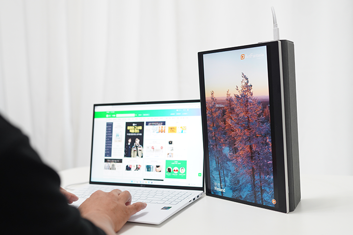LG 그램 노트북과 그램+view 포터블 모니터를 나란히 배치한 상태에서 사용자가 모니터에 출력된 화면을 바라보며 작업하는 모습