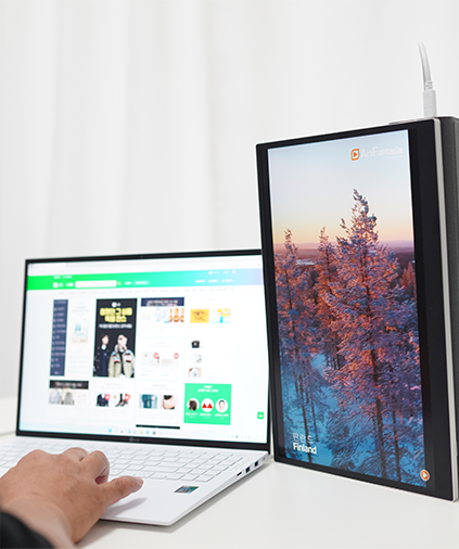 LG 그램 노트북과 그램+view 포터블 모니터를 나란히 배치한 상태에서 사용자가 모니터에 출력된 화면을 바라보며 작업하는 모습