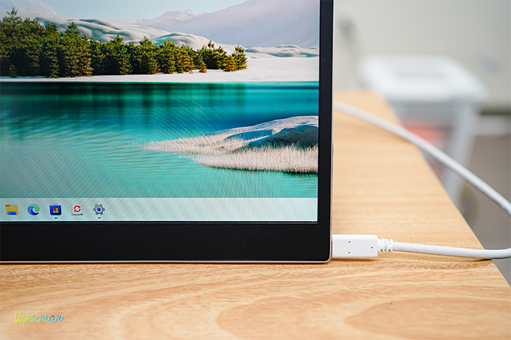 그램+view 포터블 듀얼 모니터가 USB-C 케이블을 통해 노트북과 연결된 상태로, 모니터에 아름다운 자연 풍경이 출력된 모습