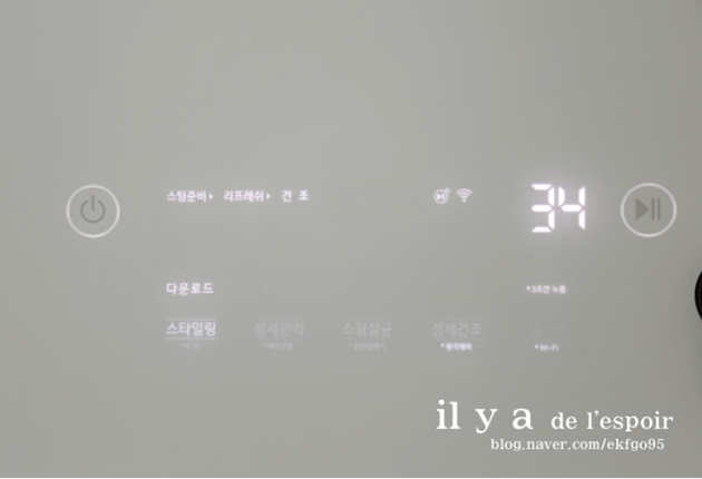 LG 스타일러의 디스플레이 화면이 켜져 있는 모습으로, 다운로드된 스타일링 코스가 표시되어 있고 남은 시간이 34분으로 나타나 있다.