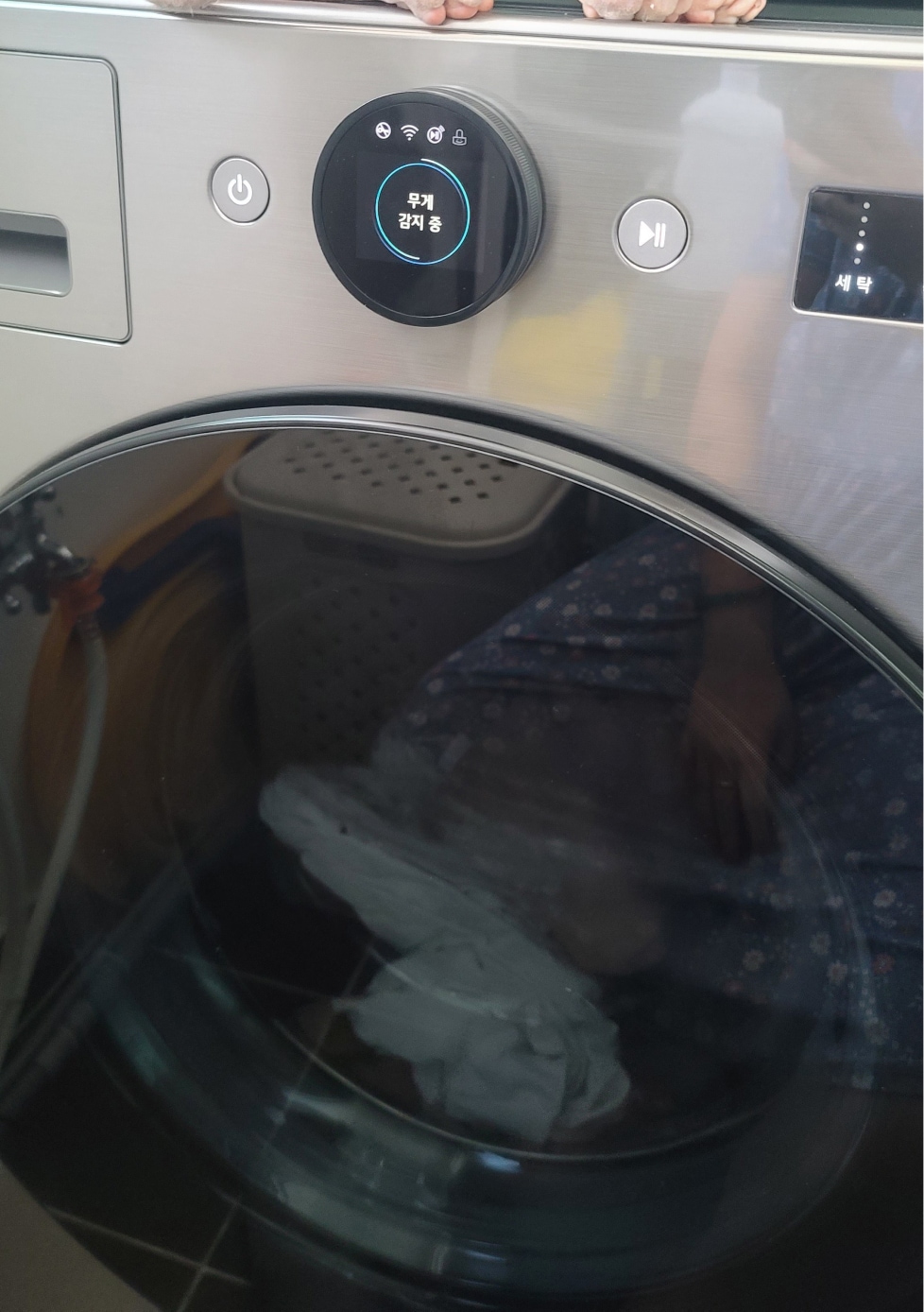 lg_트롬_세탁기_위에_고양이가_올라가_있으며_디스플레이에는_무게_감지_중이라고_표시된_모습.