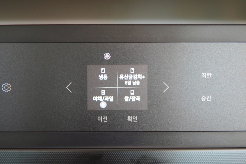 냉장고_디스플레이_화면에_여러_가지_옵션이_보임._냉동,_야채/과일,_쌀/잡곡_등의_메뉴가_선택_가능하고,_유산균김치가_6일_남았다는_정보도_표시됨.