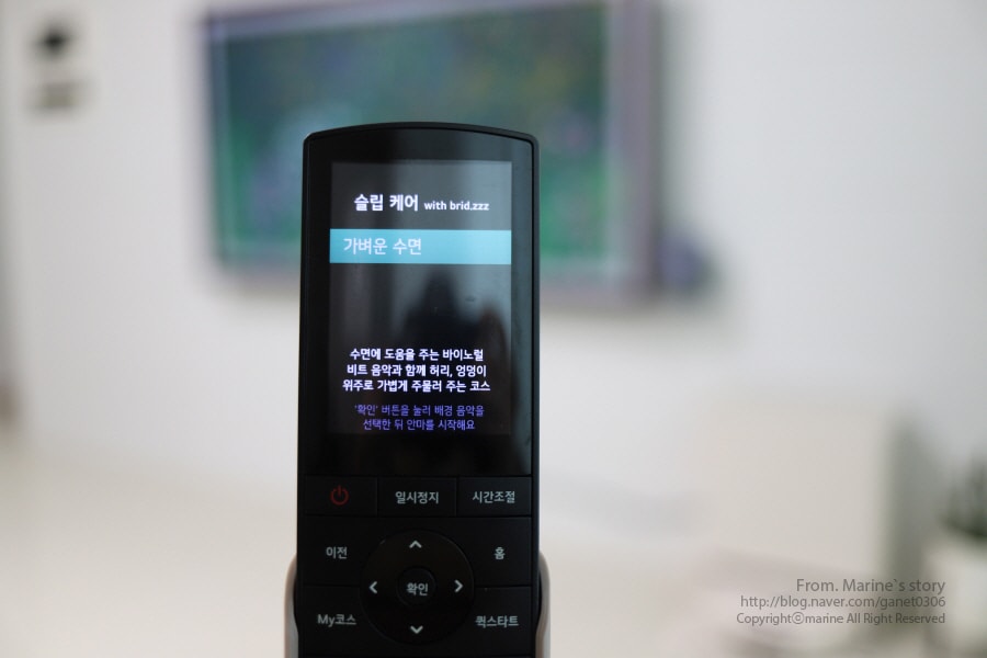lg_힐링미_안마의자_리모컨으로_슬립케어_코스의_음악을_선택하는_모습