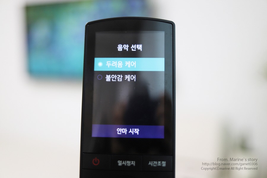 lg_힐링미_안마의자_리모컨으로_마인드_케어_코스의_음악을_선택하는_모습