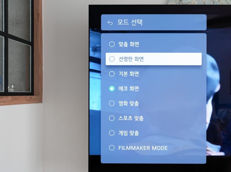 lg_signature_oled_m_tv_화면에_모드_선택_설정_메뉴가_표시되고_있다._사용자는_에코_화면을_선택한_상태이며,_화면_모드_옵션으로_맞춤_화면,_선명한_화면,_기본_화면,_영화_맞춤,_스포츠_맞춤,_게임_맞춤,_filmmaker_mode가_나열되어_있다.