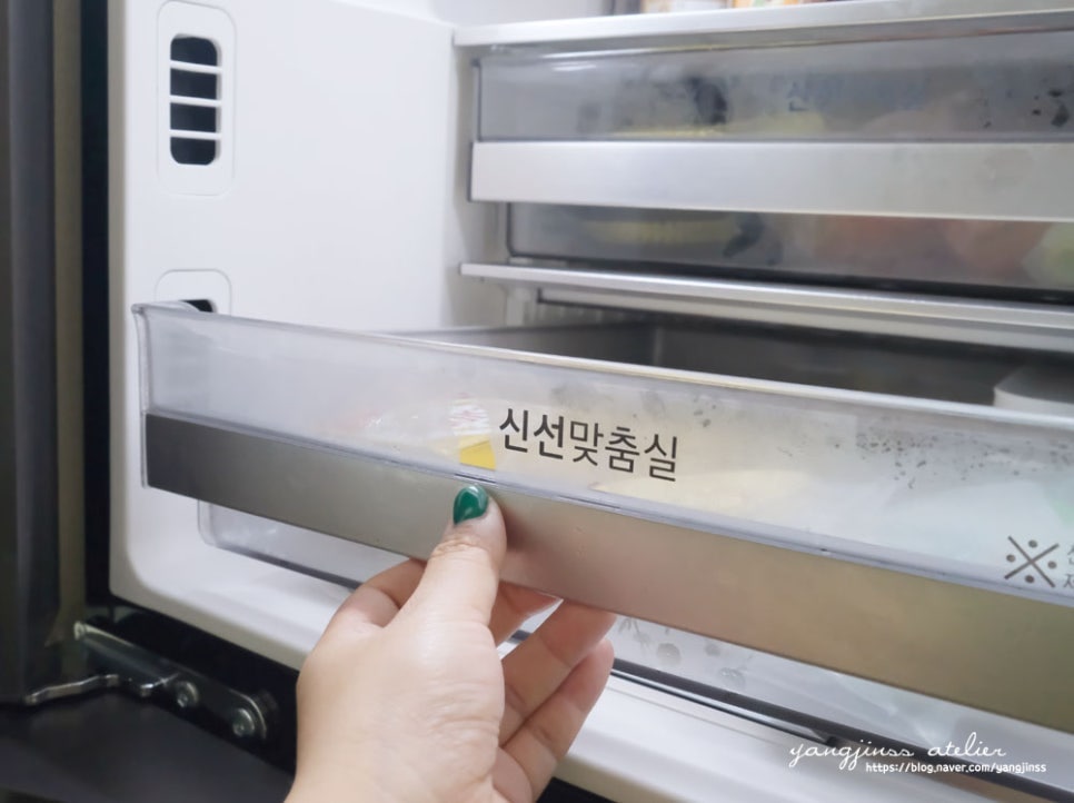 사용자가 냉장고 내부 ‘신선맞춤실’ 서랍을 열고 있는 모습