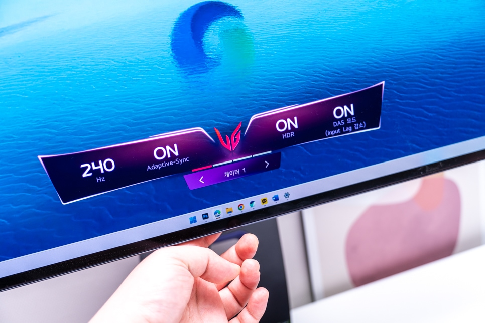 모니터의 설정 메뉴, 240Hz 주사율, Adaptive-Sync, HDR, DAS 모드가 활성화된 상태로, 손으로 메뉴를 조작하며 직관적인 사용자 경험을 제공함.