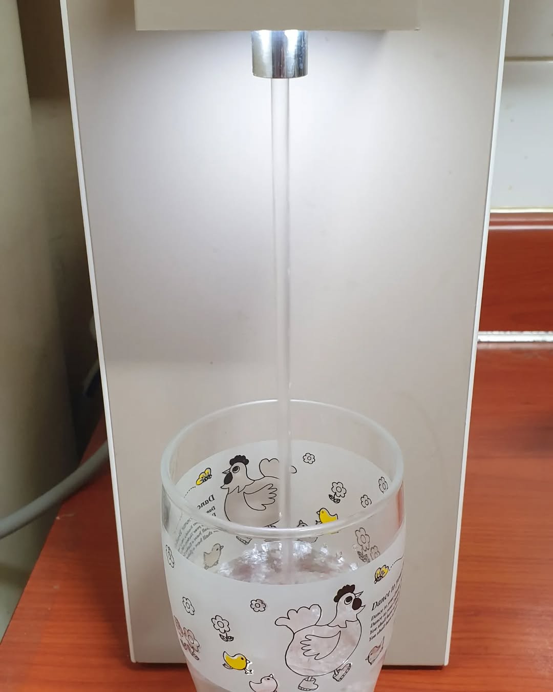 정수기로 컵에 물을 따르고 있는 모습