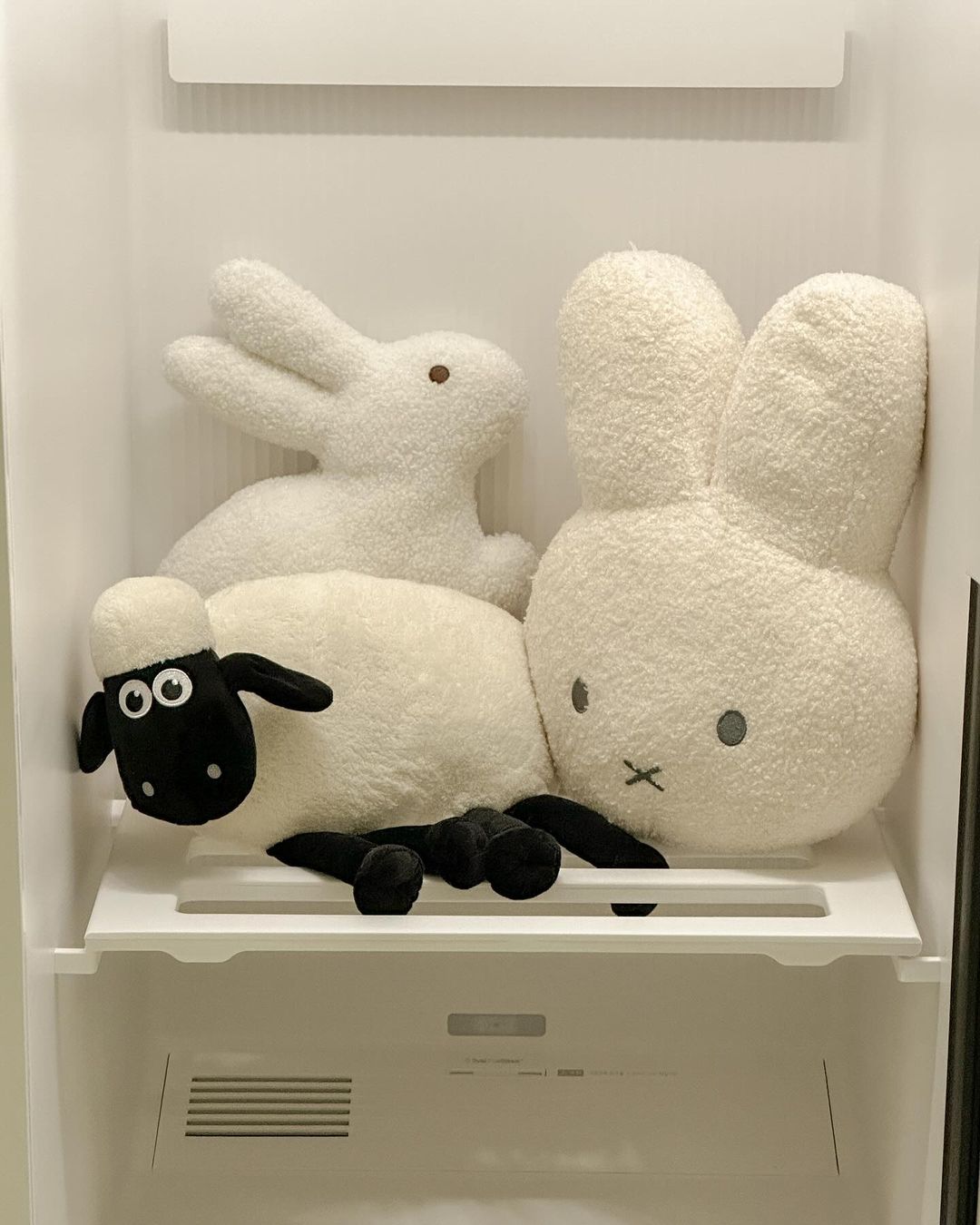 스타일러 내부 선반에 흰색 토끼와 양 모양의 인형 3개가 놓여있음.