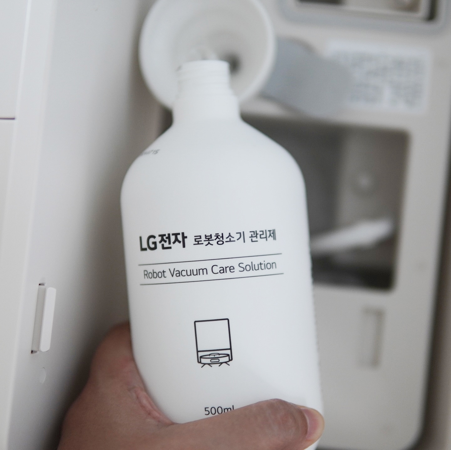 코드제로 로보킹 전용 관리제(500ml) 용기를 손으로 잡고 있는 모습.