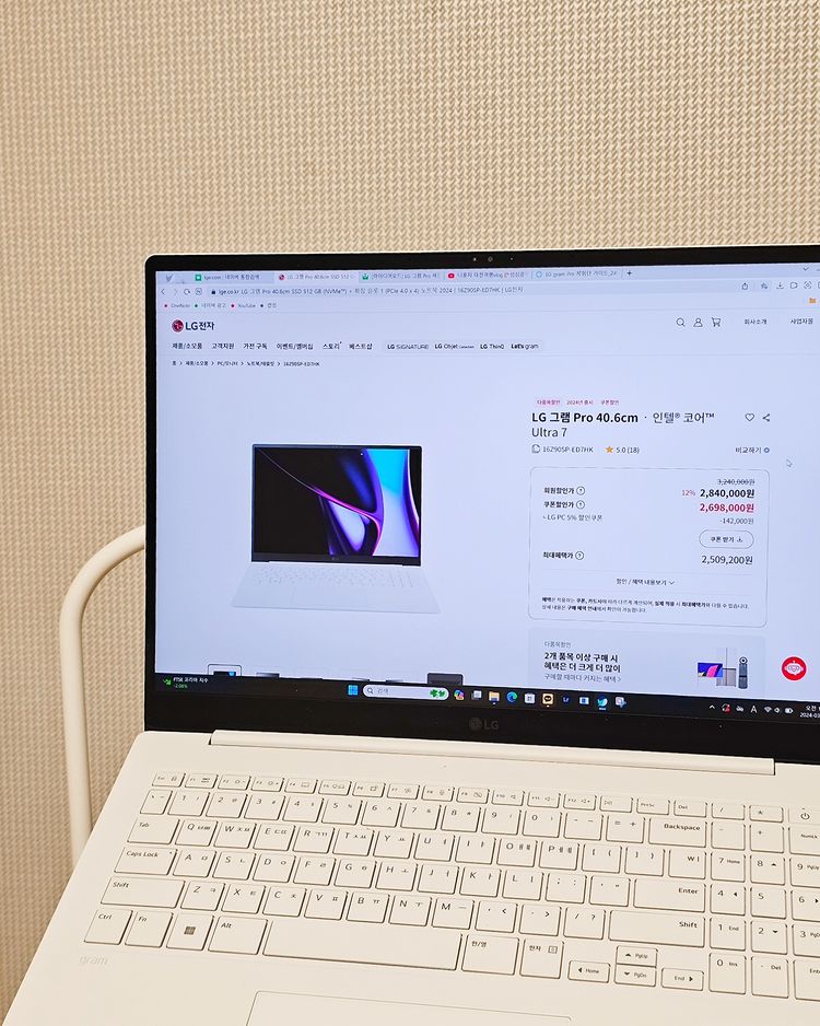 LG 그램 노트북이 책상 위에 있으며, 화면에는 LG전자 공식 홈페이지에서 LG 그램 Pro 제품 정보가 표시됨.