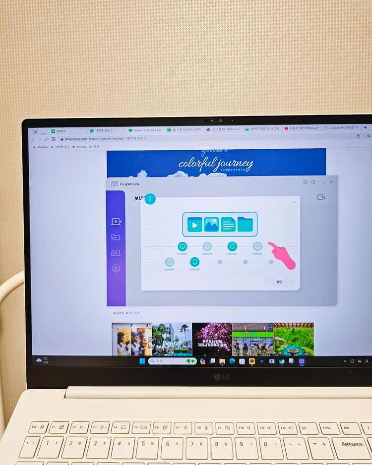 LG 그램 노트북이 책상 위에 있으며, 화면에는 LG gram Link 프로그램이 실행 중임. 파일 전송 안내 그래픽과 웹 브라우저가 열려 있음.