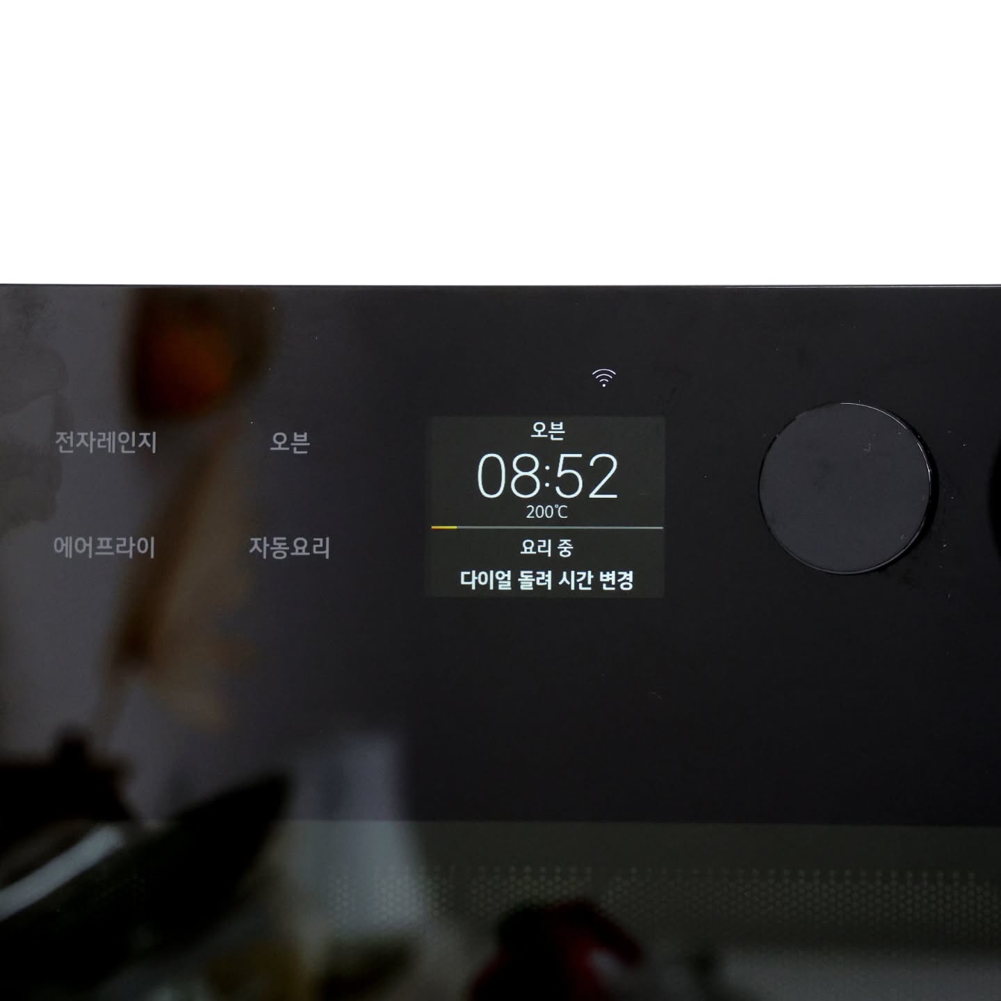 광파오븐 조작부를 확대한 것. 디스플레이에 오븐 조리 중이라는 것이 표시되어 있다.