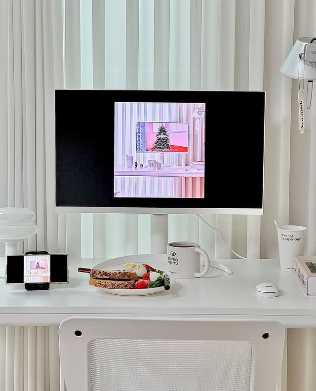 LG 스마트 모니터를 활용해 스마트폰 화면을 공유하는 모습. 모니터와 스마트폰에 동일한 영상이 재생되고 있으며, 깔끔한 화이트 인테리어와 자연광이 어우러진 공간이 돋보인다.