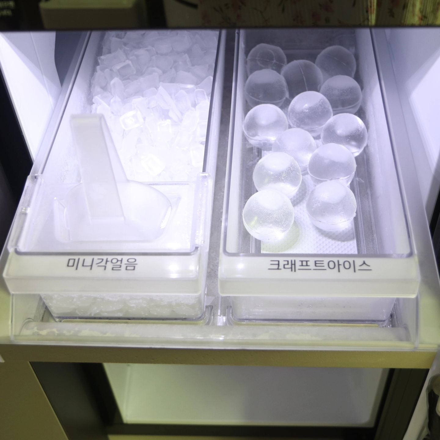 얼음정수 냉장고 내부 아이스 서랍에 담긴 사각 얼음과 둥근 얼음이 보이는 모습으로, 다양한 형태의 얼음을 제공함.