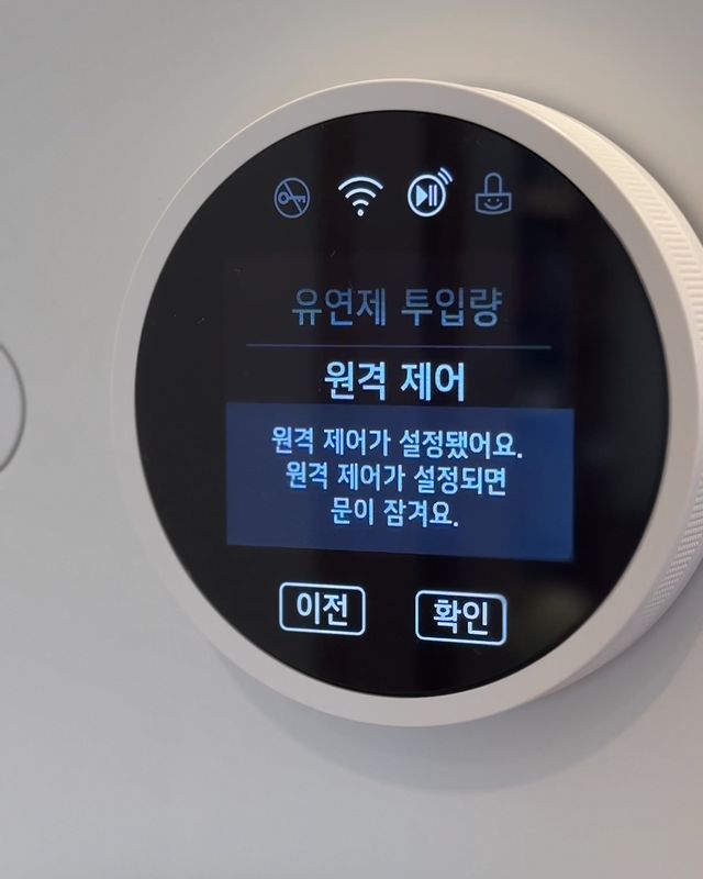 워시콤보 디스플레이 화면에 유연제 투입량을 원격 제어 모드로 설정과 하단에는 이전과 확인 버튼이 보임.
