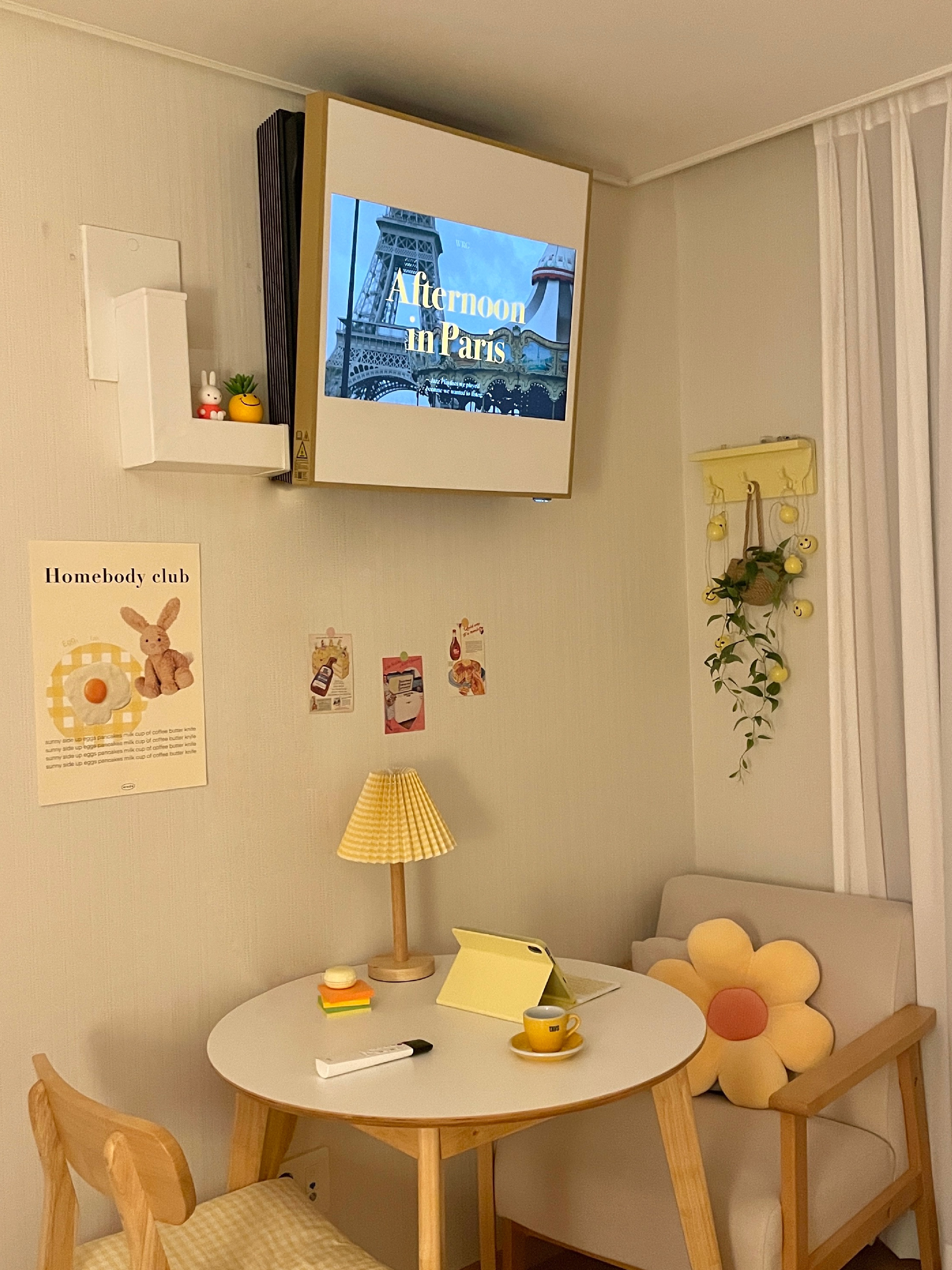 LG 휘센 오브제컬렉션 아트쿨 에어컨이 벽에 설치되어 있고, 화면에 Afternoon in Paris 텍스트와 에펠탑이 보이는 모습.