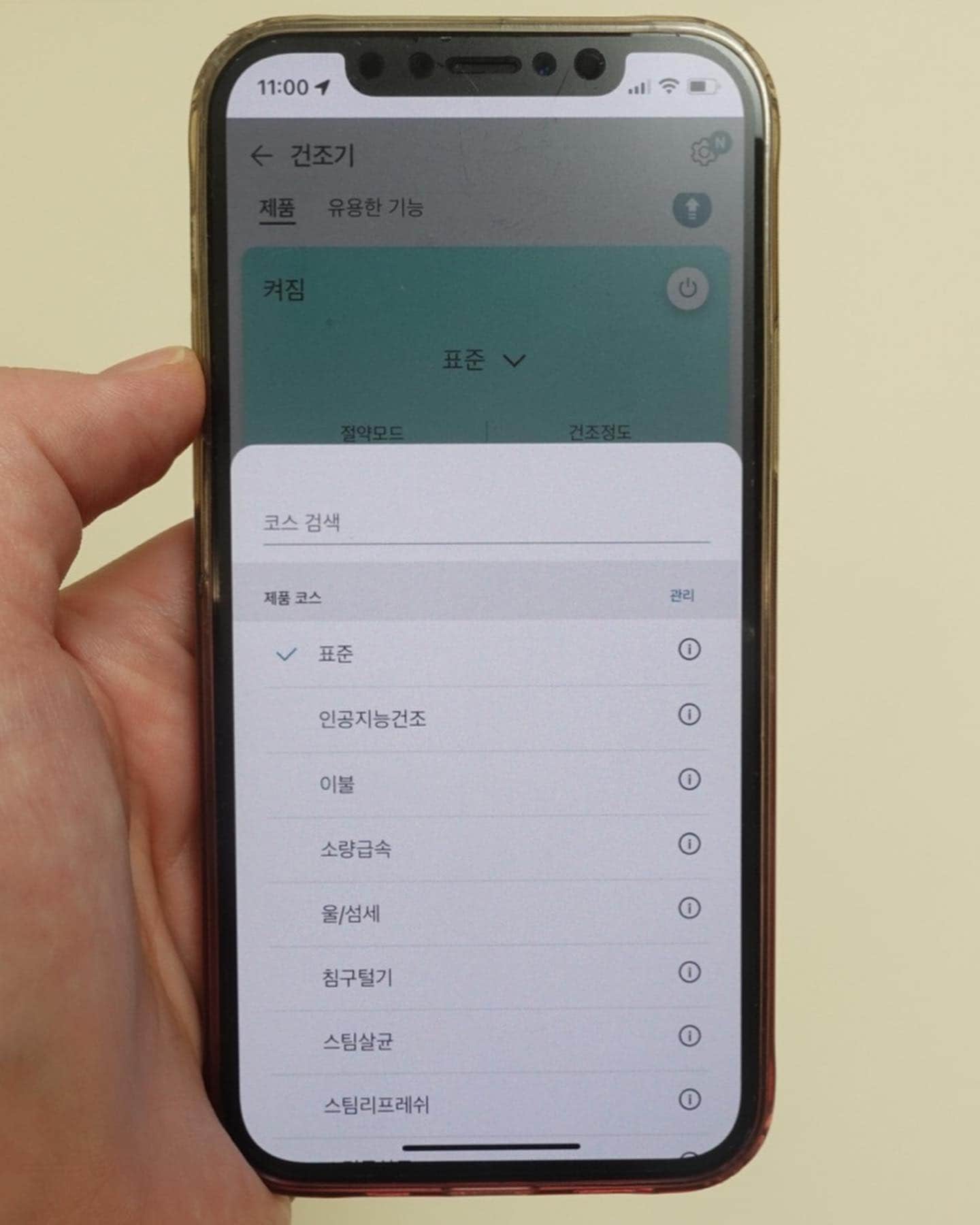 스마트폰 화면에 LG 트롬 오브제컬렉션 건조기의 다양한 건조 코스가 표시된 모습.