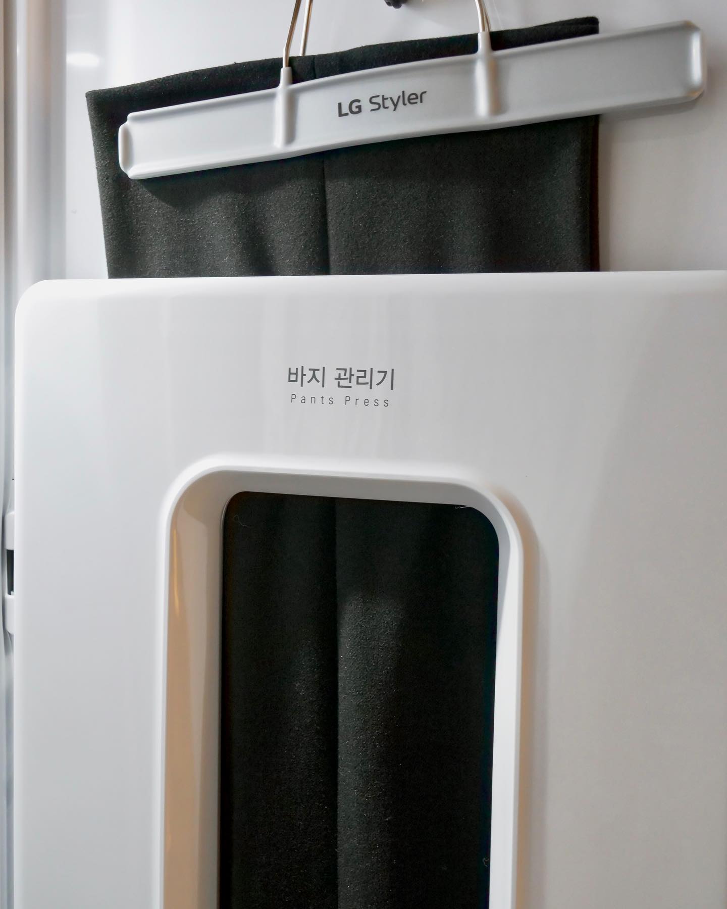 LG 스타일러의 바지 관리기 내부 모습으로, 바지가 전용 걸이에 걸려 관리되고 있는 모습.