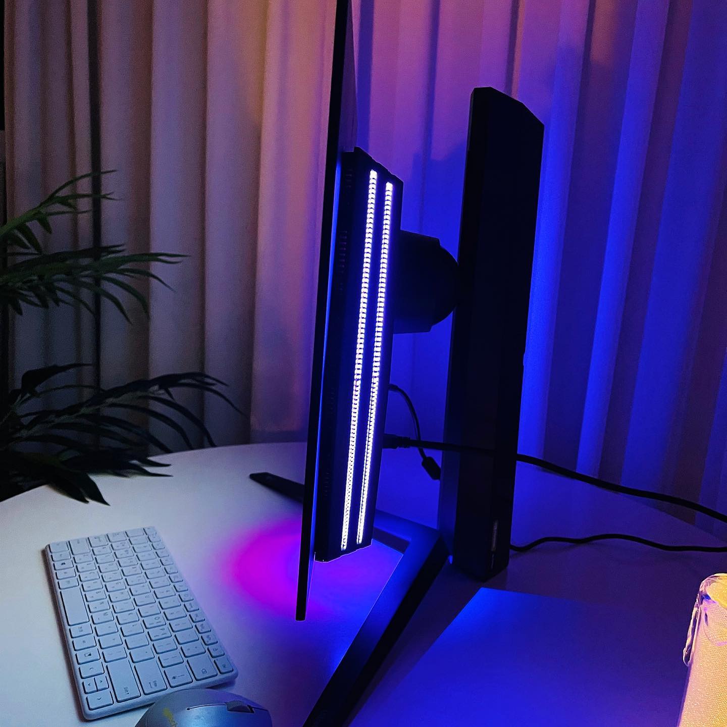 컴퓨터 모니터 뒤쪽에 LED 라이트가 켜져 있는 모습.