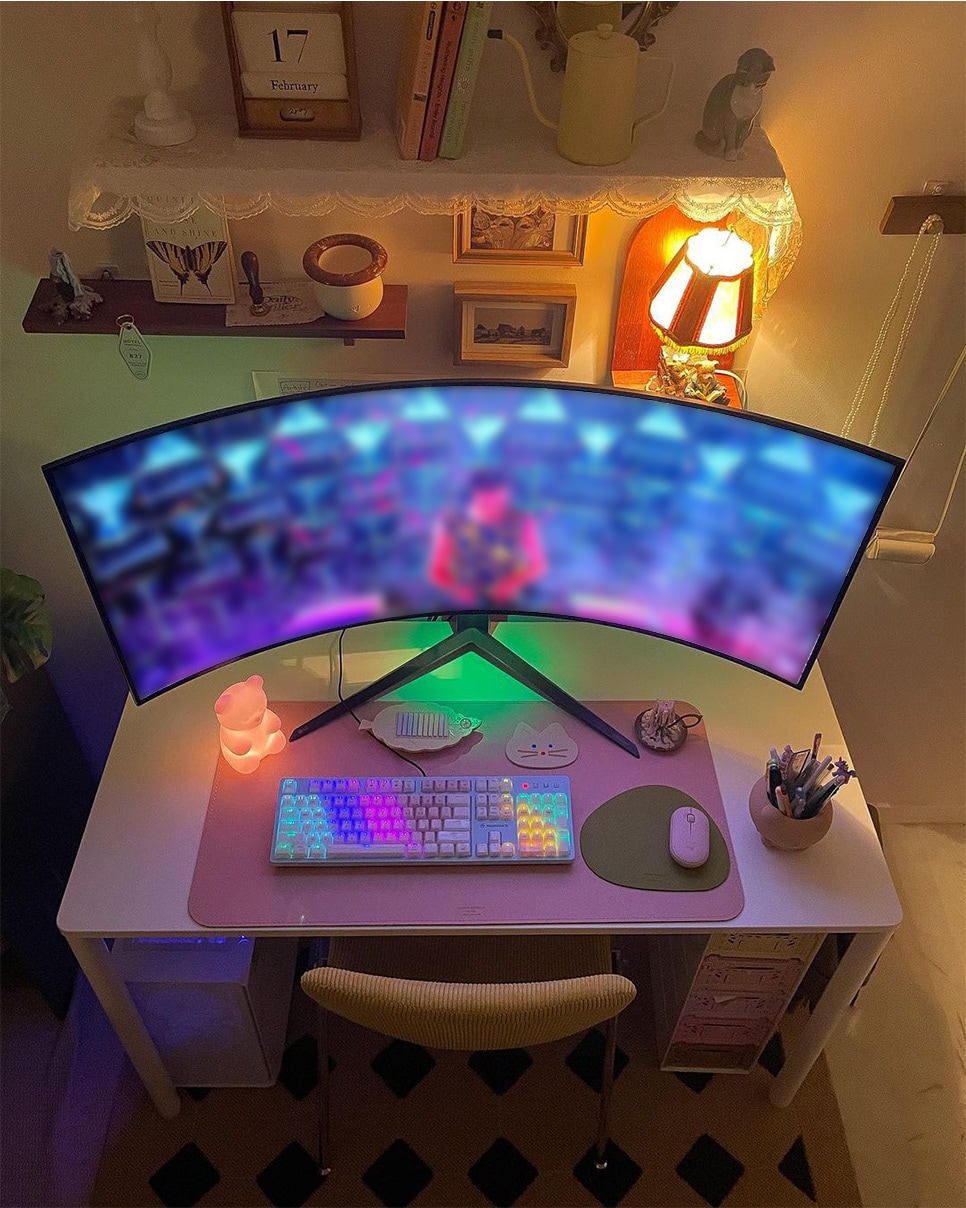 책상 위에 LG 울트라와이드 게이밍 모니터가 놓여 있고, RGB 조명이 켜진 키보드와 마우스가 함께 배치된 모습.
