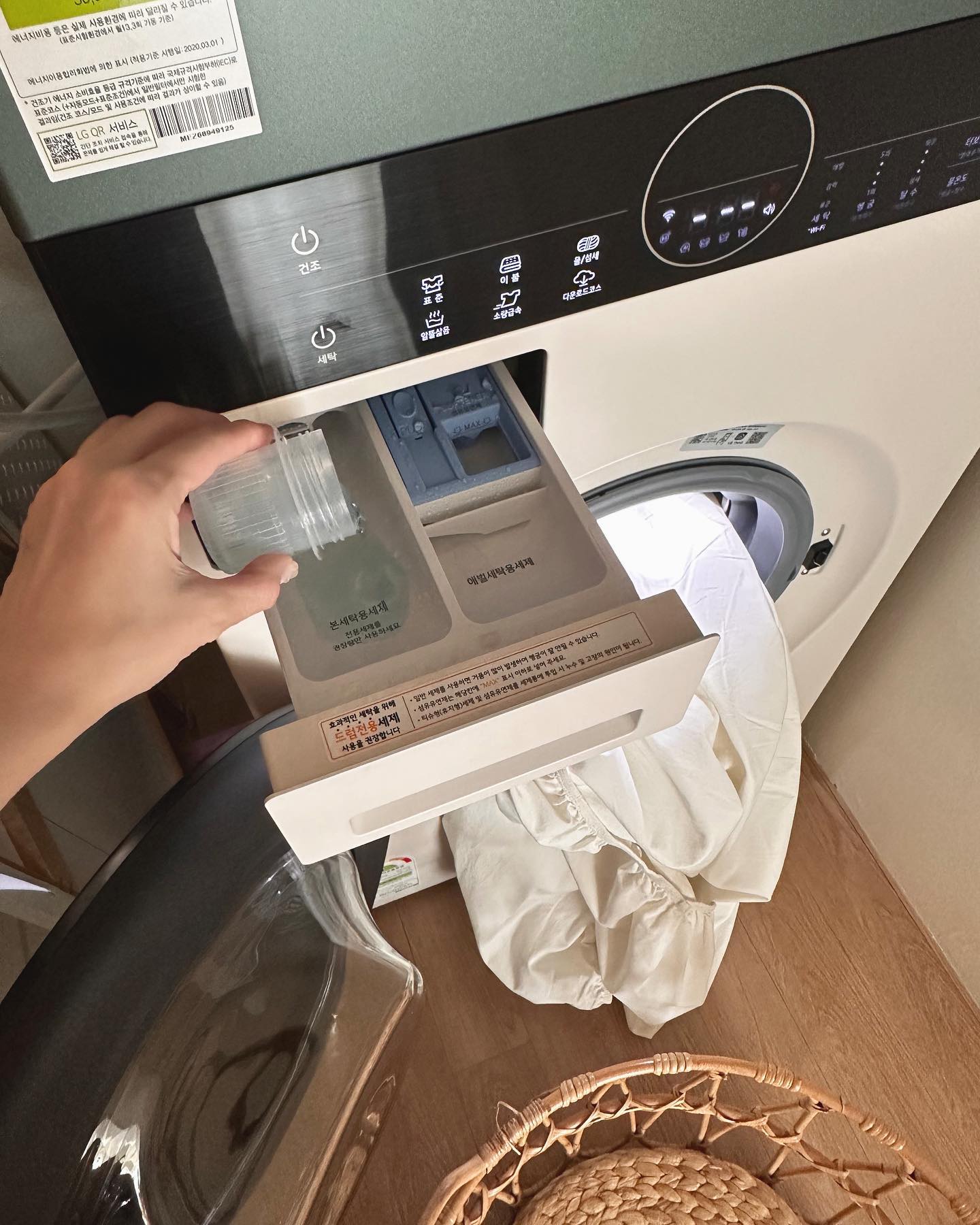세제 칸에 액체를 붓고 있는 세탁기의 근접 화면