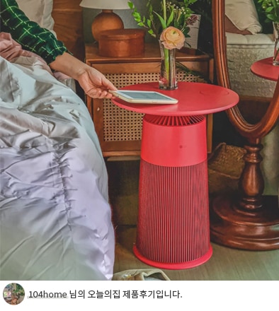 붉은 색상의 LG 퓨리케어 오브제컬렉션 에어로퍼니처가 테이블 역할을 하는 모습과 하단에 '104home 님의 오늘의집 제품후기입니다' 텍스트가 포함된 모습.