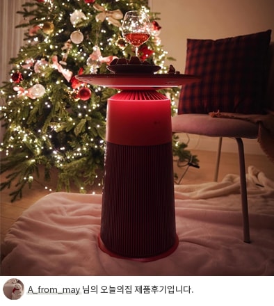 크리스마스 트리 옆에 위치한 LG 퓨리케어 오브제컬렉션 에어로퍼니처의 모습과 하단에 'A_from_may 님의 오늘의집 제품후기입니다.' 텍스트가 포함된 모습.