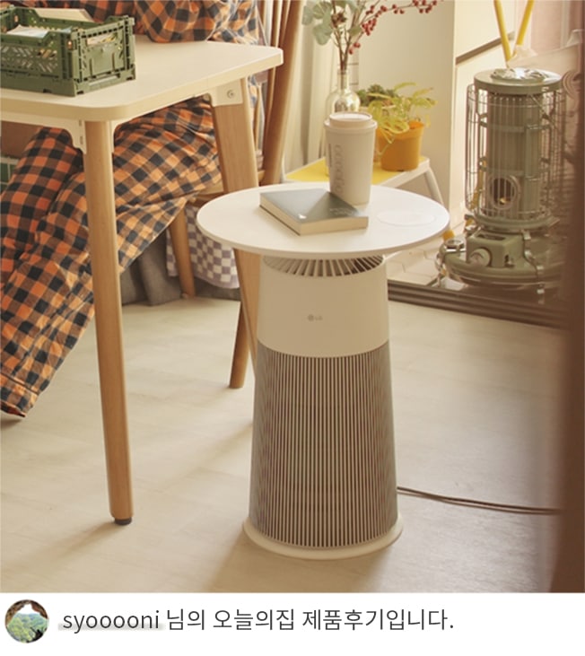 LG 퓨리케어 오브제컬렉션 에어로퍼니처가 커피잔과 책을 올려놓은 테이블로 사용되는 모습과 'Syooooni 님의 오늘의집 제품후기입니다.' 텍스트가 포함된 모습.