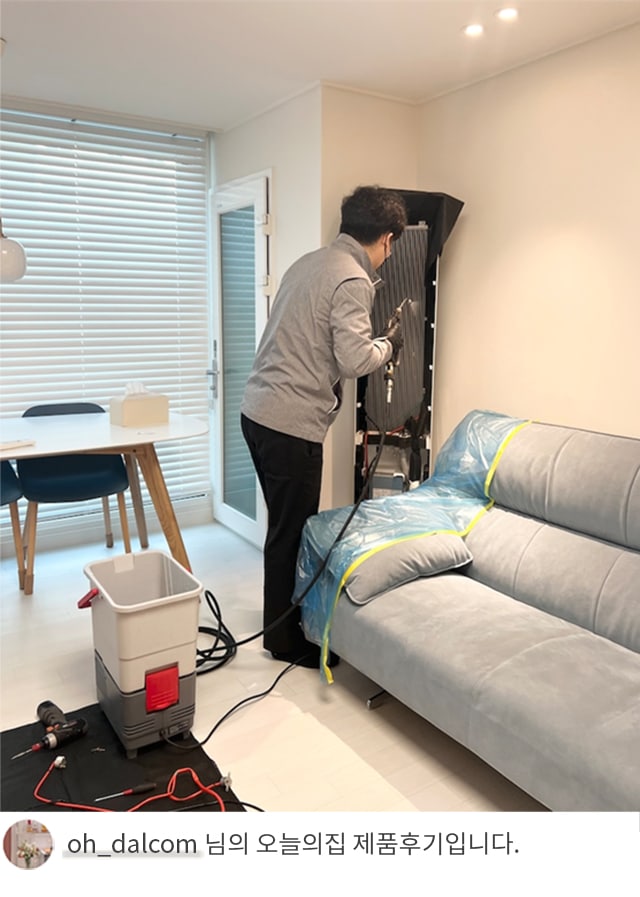 전문 기술자가 LG 휘센 오브제컬렉션 에어컨을 점검하고 청소하는 모습. 바닥에는 작업 도구와 보호 매트가 배치되어 있으며, 'oh_dalcom 님의 오늘의집 제품후기입니다.' 텍스트가 포함된 이미지.