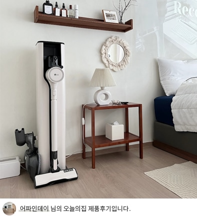 LG 코드제로 오브제컬렉션 A9S 무선청소기가 침실 벽 옆에 놓인 모습. 화이트톤 벽과 나무 선반, 아늑한 침구가 어우러진 공간에 청소기가 잘 배치되어 있으며, 하단에는 '어파인데이 님의 오늘의집 제품후기입니다.'라는 텍스트가 포함되어 있음.