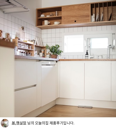 LG 디오스 오브제컬렉션 식기세척기가 포함된 주방 전경으로, 밝은 창문과 식물, 우드톤의 선반이 따뜻한 분위기를 연출합니다. 화면 하단에는 '봄, 햇살맘 님의 오늘의집 제품후기입니다.'라는 문구가 포함되어 있습니다.